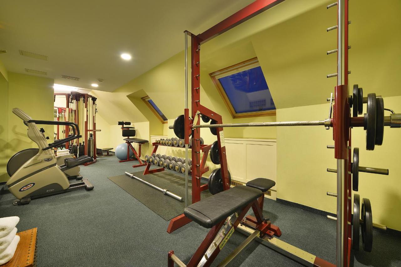 Marrol'S Boutique Hotel Bratislava Exterior foto The photo shows a small home gym or fitness area. It features various exercise equipment, including:

- A weight bench with a barbell and weight plates.
- A rack for weight plates.
- Dumbbells arranged on a rack.
- A stationary bike or elliptical mac